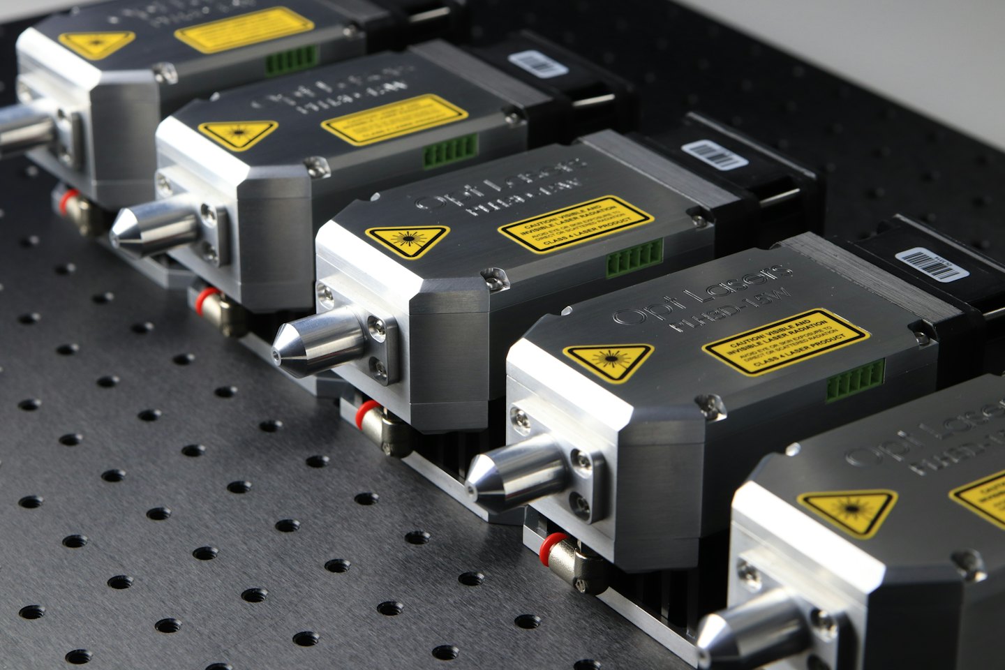 Moduli laser argentati e neri montati su una breadboard ottica.